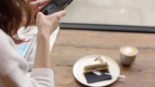 食品砂漠を撮影し ケーキセットのコーヒー写真を作る幸せな女性は 手にスマートフォンを保持し ブログやジャーナル4Kのためのコンテンツを作る 高品質4K映像 — ストック動画