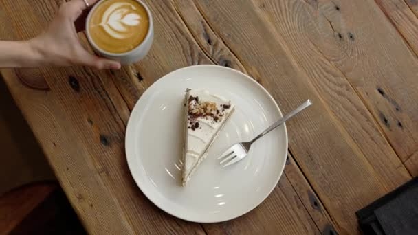 空中俯瞰巴里斯塔手的镜头 在阁楼咖啡店橱窗前的木制桌子上 拿着叉子在蛋糕边喝咖啡 慢动作4K 高质量的4K镜头 — 图库视频影像
