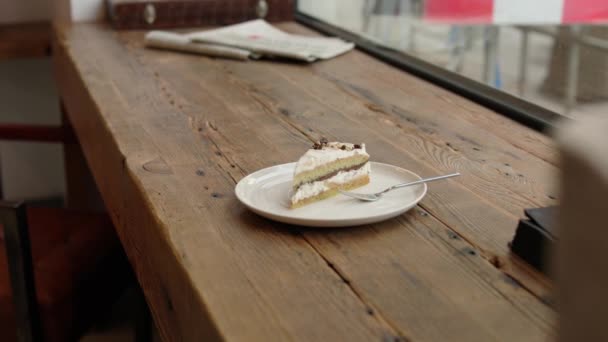 在靠近甜点蛋糕的木制桌子上放上一杯咖啡 在阁楼咖啡店或餐馆里放上叉子 高质量的4K镜头 — 图库视频影像