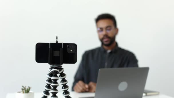 アフリカ系アメリカ人の男が同僚と話すカメラの三脚の記録に焦点を当てた 高品質4K映像 — ストック動画