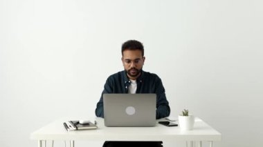 Genç Afrikalı kıvırcık saçlı genç adam dizüstü bilgisayarla oturur, internetten mesajları paylaşır, sosyal medya aracılığıyla uzaktan sohbetin tadını çıkarır. Genç nesil modern teknoloji, blog, iletişim, e-randevu kavramı kullanıyor.