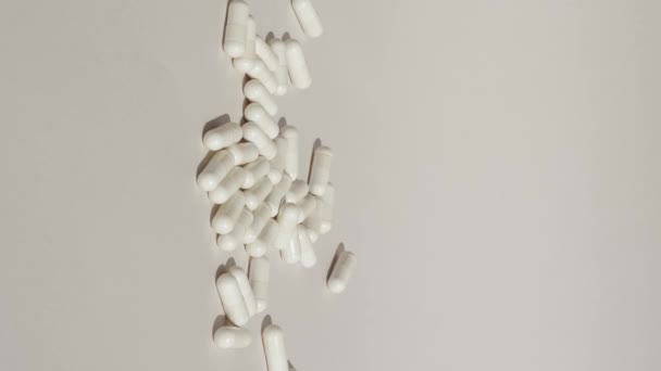 Vertical Shot White Pills Drop Grey White Surface Capsules Medicine — Stockvideo