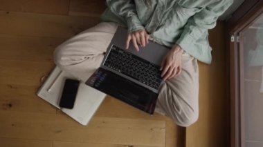 Ev Giysisi Giyen Kadın 'ın üst görünümü çapraz bacaklı ve COVID-19 Pandemic' teki Cozy Room 'da dizüstü bilgisayarda Metin Yazıyor. Kendini soyutlama. Yüksek kalite 4k görüntü