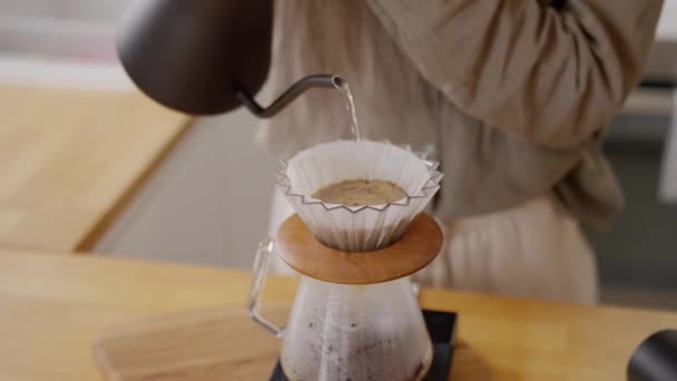 在家里厨房的木制桌子上用新鲜的咖啡豆把黑色水壶倒进V60纸袋里的水关上 高质量的4K镜头 — 图库视频影像
