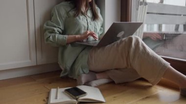 Dişi eller dizüstü bilgisayarda klavye ve dokunmatik ped kullanıyor. Evdeki oturma odasının penceresinin yanındaki dizüstü bilgisayarda çalışan kadın eli kapat. Yüksek kalite 4k görüntü