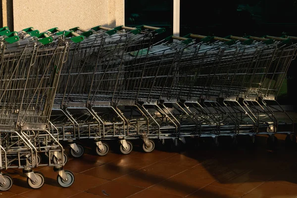 许多金属购物车停在超市附近的停车场上 购物的概念 高质量的照片 — 图库照片