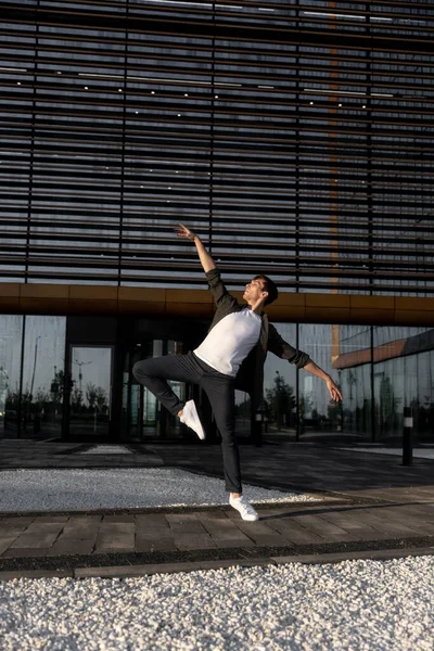 Stock image young attractive dancer in casual cloth doing ballet jump on the urban background. Contemporary dance, modern choreography. High quality photo