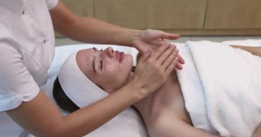 Kaplıca salonunda yüz masajı yapan çok güzel bir kız. Sağlıklı bir yaşam tarzı. Yüksek kalite 4k görüntü