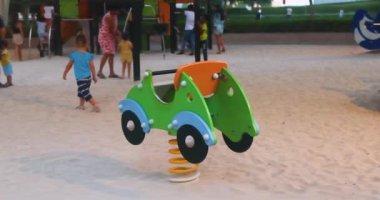 Dubai, BAE - 05.10.2022: Dubai BAE 'de hareket eden oyun parkında gün batımında çocuklar için Spring Rider oyuncağı. Yüksek kalite 4k görüntü