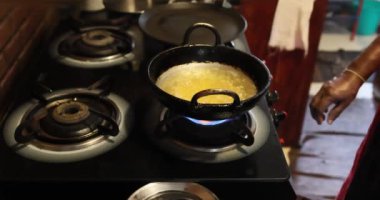 Yağlı bir tencereyi karıştıran kaynatma makinesinin yakın çekimi - Yakın çekim.. Ağır çekim. Kafkas ya da Asya mutfağı. Seçici odaklanma. Yüksek kalite 4k görüntü