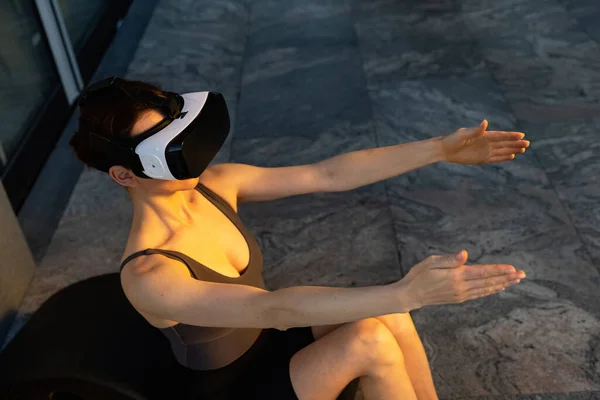 Beautiful girl doing yoga in the digital universe. Fitness of the future. Innovations. Virtual reality. VR glasses. High quality photo