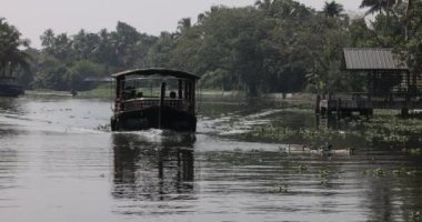Alleppey India 15 Ocak 2023: Geleneksel Kettu Valam teknesindeyken köy halkının günlük faaliyetlerini gözlemleyin. 900 km 'lik labirent su dünyası var. - Evet. Yüksek kalite 4k görüntü