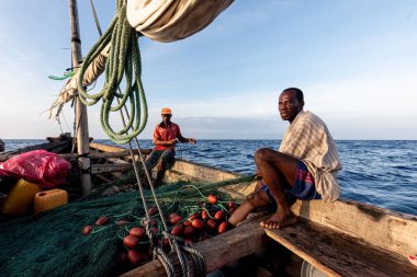 Dar es Salaam, Tanzanya - Mart 2023: Yerel balıkçılar eski bir teknede balık tutma sürecindeler. Yüksek kalite fotoğraf