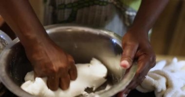 Ellerin yakın çekimi. Bir kadın Rice Idlis için hamur hazırlıyor, o da idli ya da idlis olarak heceleniyor. Güney Hindistan 'dan gelen bu popüler yemek genellikle kahvaltıda veya akşam yemeğinde servis edilir ve bir karışımdan yapılır.
