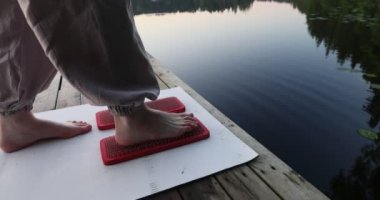 Kadınların ayakları çivili tahtaların yanında. Yoga açık havada. Çivi tahtası. Doğa. Yüksek kalite fotoğraf