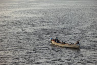 Hindistan, Kerala Eyaleti, 22 Ocak 2023: Günbatımında okyanusun arka planına karşı bir balıkçı teknesi. Yüksek kalite fotoğraf