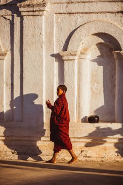 BAGAN, MYANMAR - Nisan 02, 2018: Budist rahibe yardımcısı Myanmar Thatbyinnyu Pagoda, Bagan 'ın önünde yürüyor. - Evet. Yüksek kalite fotoğraf