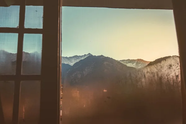 View of snow-capped Himalayan peaks through the window at dawn. High quality photo