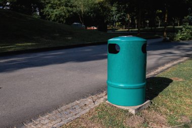Singapur parkında yeşil atık kutusu. Metal, yuvarlak ve çevre dostu. Park çöpleri için yemyeşil bir kap. Yeşil yuvarlak çöp kutusu. Ekoloji konsepti. Metal yeşil çöp kutusu. Yüksek kalite fotoğraf