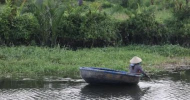 Geleneksel Vietnam teknesiyle kürek çeken bir kadın. Yüksek kalite 4k görüntü