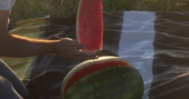 Adam kesiyor ve kadına bir parça karpuz veriyor. Karpuz kokusundan hoşlanıyor. Yüksek kalite 4k görüntü