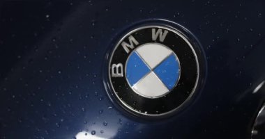 Berlin, Almanya... 10.04.2022 BMW logosu yeni bir arabanın kaputunda. Servis az önce arabayı yıkadı. Logonun etrafında su damlacıkları var. Yüksek kalite 4k görüntü