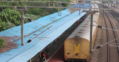 Hindistan 'daki tren çatılarının Hint tren rayları boyunca hareket edişinin görüntüsü. Tren raylar üzerinde seyahat eder. Trenler istasyona varır. Hindistan 'ın eski trenleri. Yüksek kalite 4k görüntü
