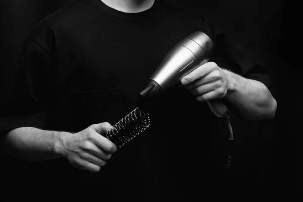 hair dryer and comb in barbers hands. High quality photo