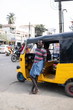 Mysore, Hindistan - 27 Ekim 2023: Hintli bir adam triportör ya da tuk-tuk fotoğrafının önünde duruyor. Yüksek kalite fotoğraf
