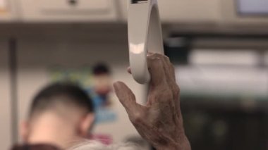 Bir trenin el ele tutuşan yolcusu trenin tırabzanı yaşlı bayanların ellerini toplu taşımada yüzüncü sınıfa kadar uzatıyor. Yüksek kaliteli FullHD görüntüler