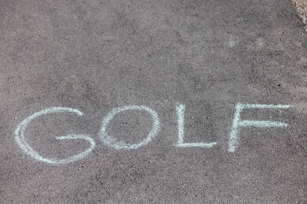 stock image word golf written in white chalk on an asphalt surface or road. High quality photo