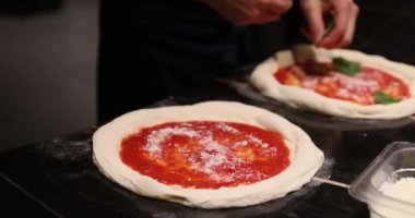 Pizzacı pizza yapıyor. Şef restoran mutfağında pizza hazırlıyor. Domates sosu pizza hamurunu koyuyor. Pizza pişiriyorum. Yüksek kalite 4k görüntü