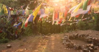 Akciğer ta dua bayrakları dağ yolunda asılı renkli Tibet dua bayrakları dingin rüzgar şehrine dingin ruhsal enerjinin huzur sembolü olan eski duaları dalgalanıyor. Yüksek kalite 4k görüntü
