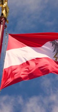 Avusturya Bayrağı 'nın arkaplanda Avusturya Ulusal Günü' nde mavi bulutlu bir gökyüzü olan bir direkte dalgalanması. Yüksek kalite 4k görüntü