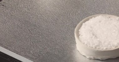 Gri masadaki kasede organik beyaz tuz, üst manzara. Yüksek kalite fotoğraf