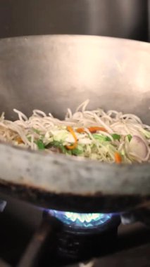 Buranın sakini eriştenin üzerine baharatlı sos döker. Hint sokak yemeği. Yüksek kalite 4K görüntü. Yüksek kalite 4k görüntü