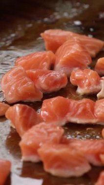 Tavada cızırdayan yağda küçük kırmızı balık parçaları. Balık pişiriyorum. Somon balığı. Yüksek kalite 4k görüntü