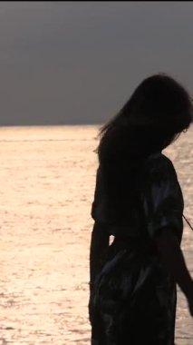 Siluet güzel sarışın kadın gün batımında sahilde koşuyor. Arka farlar. Süper yavaş çekim 4K. Yüksek kaliteli FullHD görüntüler