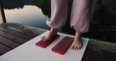 Kadınların ayakları çivili tahtaların yanında. Yoga açık havada. Çivi tahtası. Doğa. Yüksek kalite fotoğraf