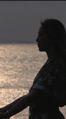 Siluet güzel sarışın kadın gün batımında sahilde koşuyor. Arka farlar. Süper yavaş çekim 4K. Yüksek kaliteli FullHD görüntüler