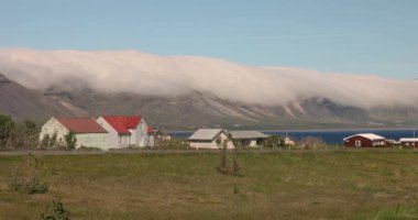 İzlanda 'da çarpıcı kırsal alanlar, kuzeydeki çiftlik evleri güneşli bir günde Hilly manzarası, yeşil çayırlar, dokunulmamış güzel doğa manzarası. Yüksek kalite 4k görüntü
