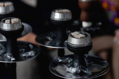 Nargilede yanan közler. Nargile sigara konsepti. Kalaud, nargile tabağındaki kömür maşaları doğada duruyor. Yüksek kalite fotoğraf