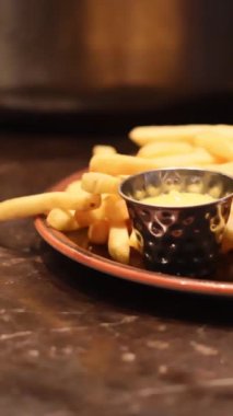 Elle patates kızartması ve soğanlı sığır burger yemek ve tepside servis yapmak. Yüksek kalite 4k görüntü