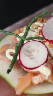 Turp, elma ve kuşkonmazla servis edilen pembe Himalaya tuz bloğunda taze balık sunumu. Haute cuisine konsepti. Yüksek kalite 4k görüntü