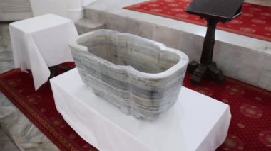 Bir bebeğin Hıristiyan vaftizinin yazı tipi. Vaftiz fontu, vaftiz töreni, vaftiz havuzu, vaftiz kabı, vaftiz kabı. Yüksek kalite 4k görüntü
