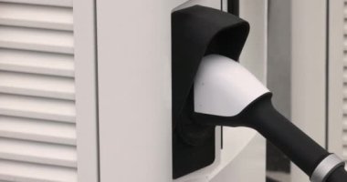Kapalı EV şarj kolu fişe takıldı veya elektrikli arabaya bağlandı, EV araba aküsünü temiz çevre için sıfır CO2 emisyonu ile alternatif ve sürdürülebilir enerjiyle şarj etti. Yüksek kalite 4k görüntü