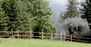 Antika bir buharlı lokomotif orman yolunda dumanla çevrili bir şekilde tıkırdıyor. Yüksek kalite 4k görüntü