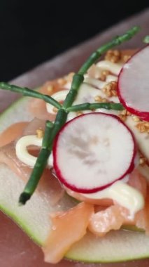 Turp, elma ve kuşkonmazla servis edilen pembe Himalaya tuz bloğunda taze balık sunumu. Haute cuisine konsepti. Yüksek kalite 4k görüntü
