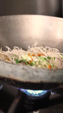 Buranın sakini eriştenin üzerine baharatlı sos döker. Hint sokak yemeği. Yüksek kalite 4K görüntü. Yüksek kalite 4k görüntü