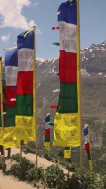 Akciğer ta dua bayrakları dağ yolunda asılı renkli Tibet dua bayrakları dingin rüzgar şehrine dingin ruhsal enerjinin huzur sembolü olan eski duaları dalgalanıyor. Yüksek kalite 4k görüntü